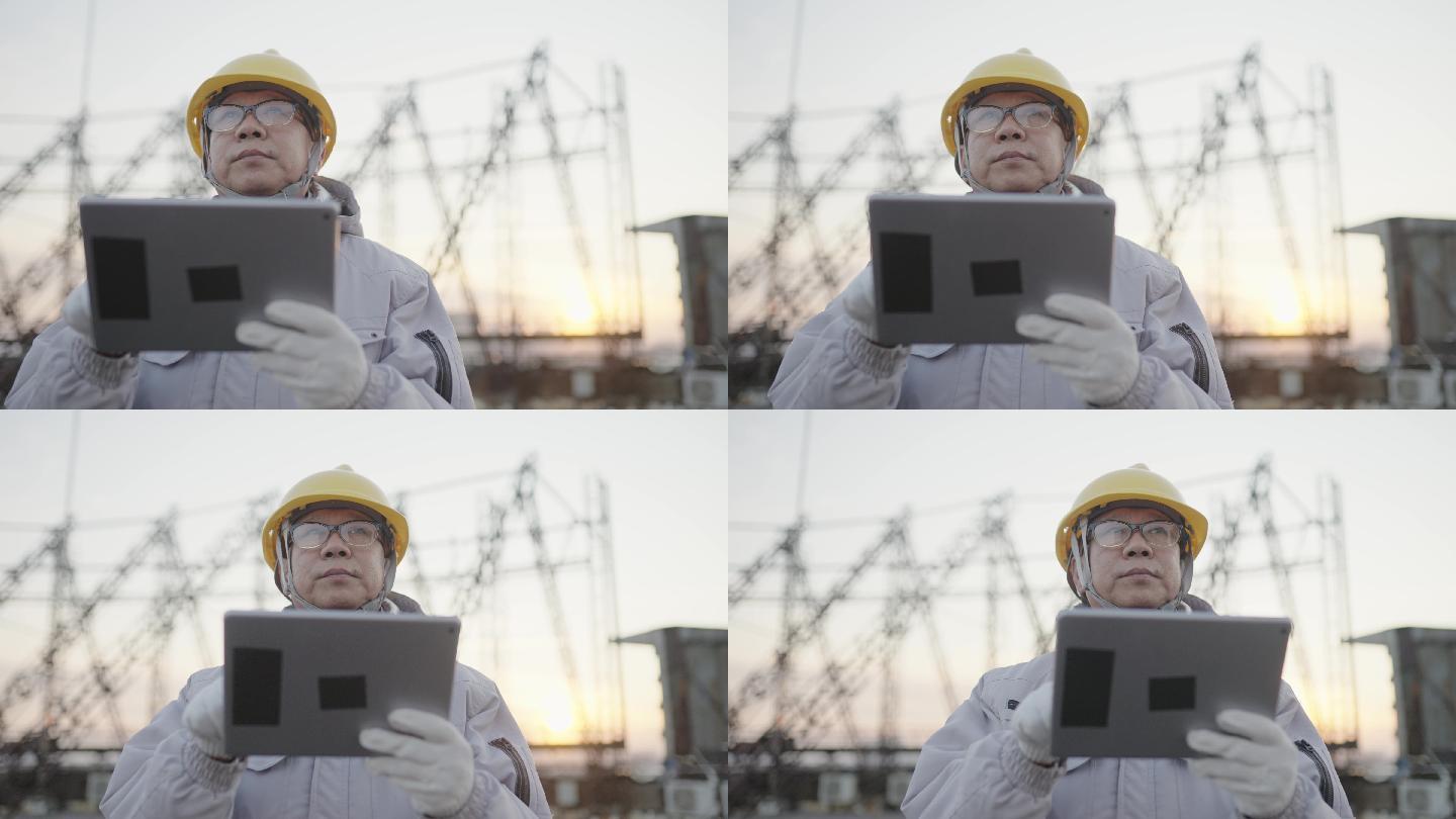 亚洲工程师在户外操作iPad维护设备，穿着工作服和安全帽