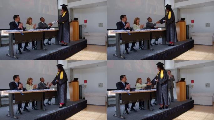 非裔美国女研究生在获得大学文凭时与董事会成员握手