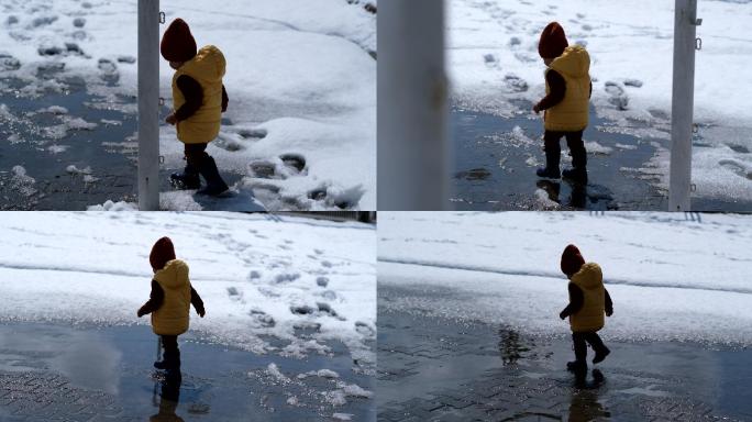 初学走路的男孩喜欢在春天的一天在外面的水坑里玩耍