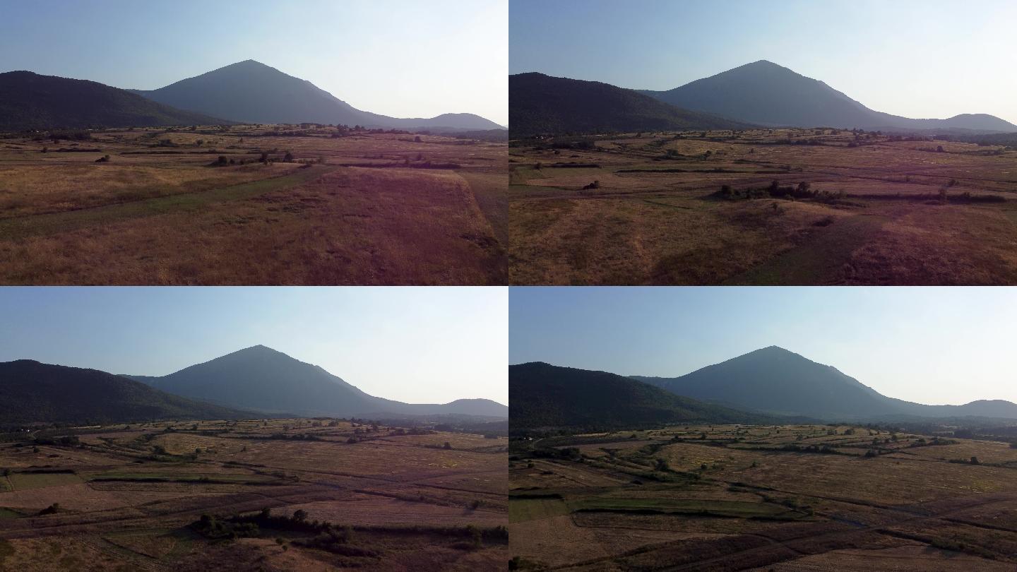 日落时飞过一片草地，朝着一座金字塔形的山飞去，塞尔维亚东部的阿尔坦杰山
