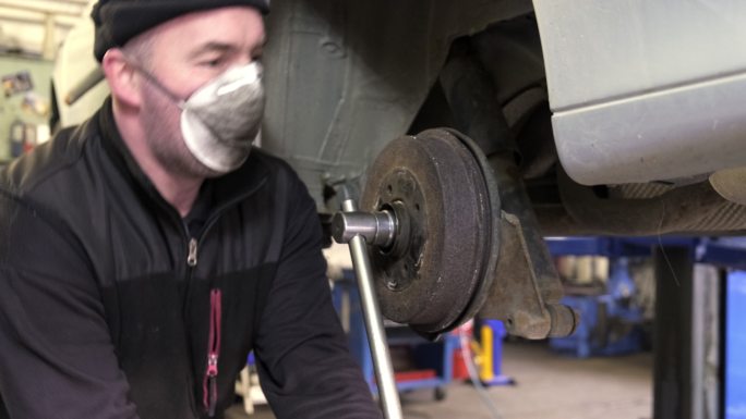 汽车修理工在汽车上安装车轮轴承