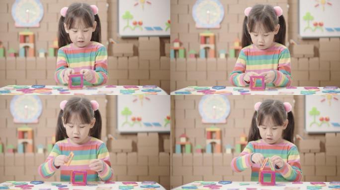 可爱的小女生在家里玩和试验磁性积木