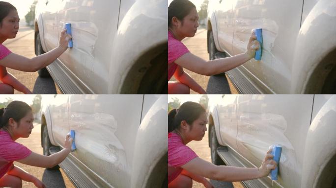 女士用毛巾和洗车液洗车