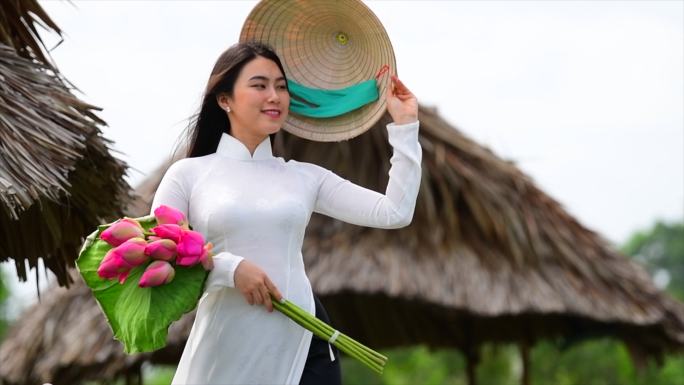 越南荷花田上越南妇女抱着荷花的慢镜头