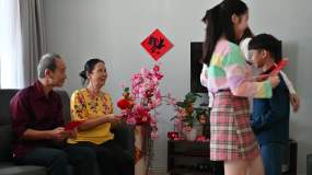 中国新年期间，亚洲家庭在客厅迎接并收到父母和祖父母的中国新年红包（Angpow）视频素材
