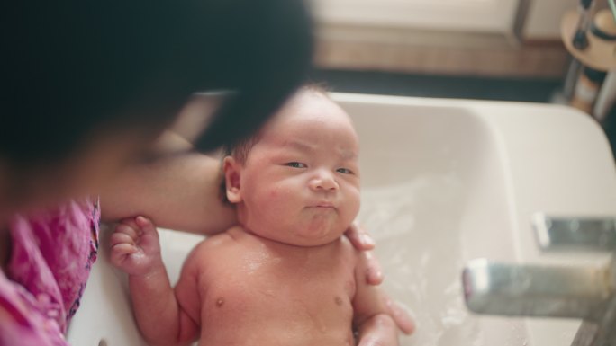 可爱的男婴在水槽里洗澡