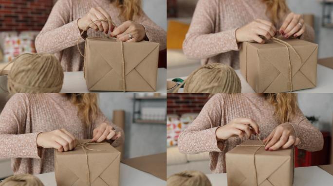 那个女人用纸把盒子包好，准备送出去。她在家里的工作室工作