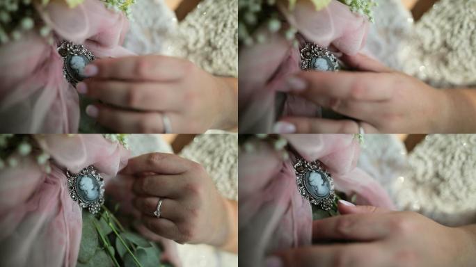 新娘手上戴着戒指，手上拿着带奖章的婚礼花束