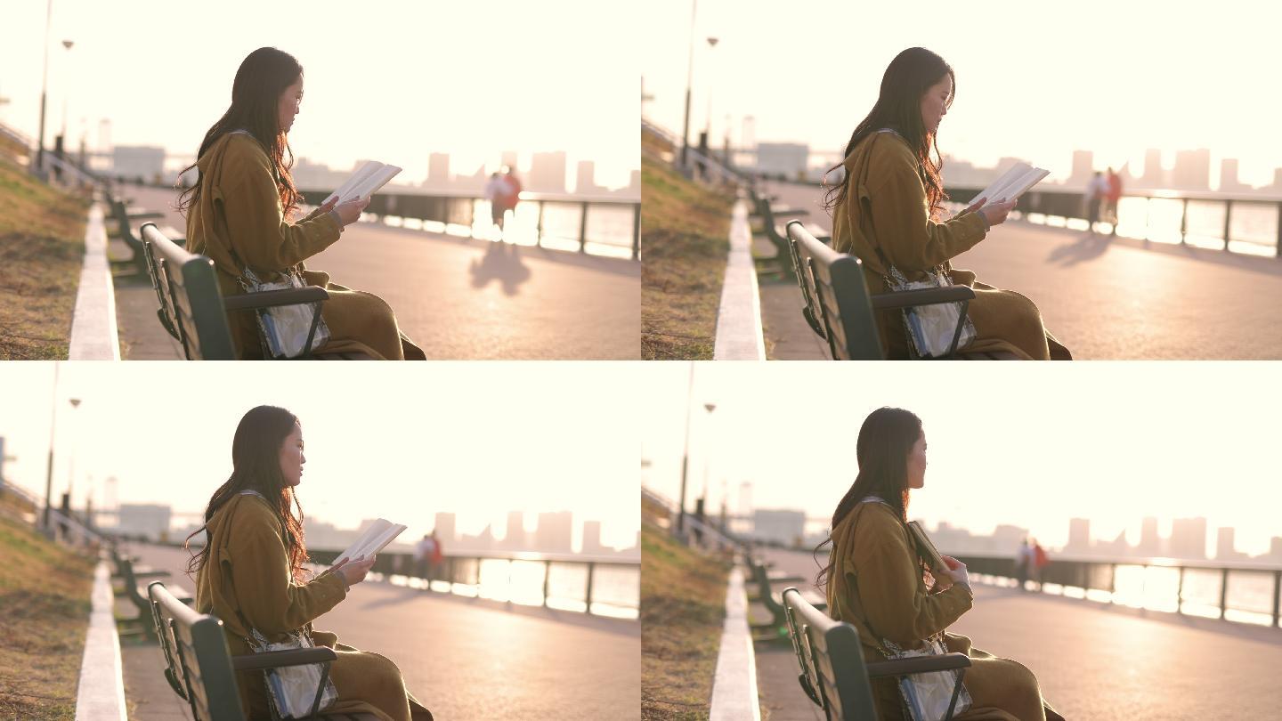 日落时分，年轻女子在海滨公园看书-第2部分，共2部分