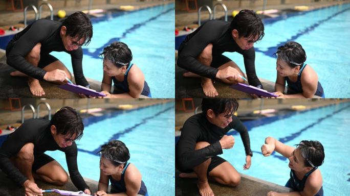 中国亚裔私人教练在结束教育和训练课程后，在泳池边向他的学生展示游泳考试成绩