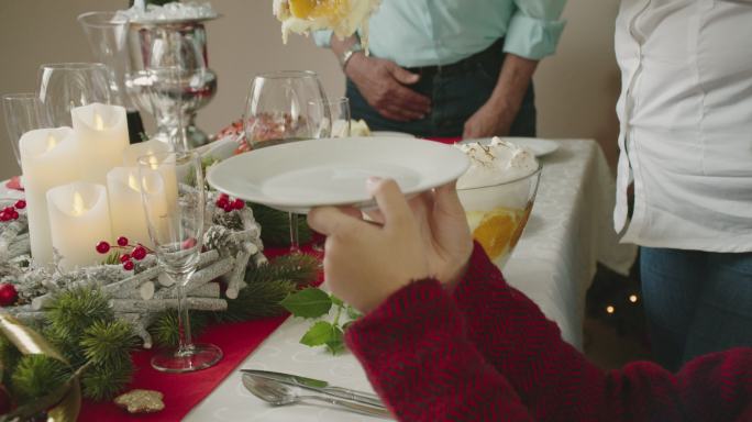 一家人正在享用圣诞晚餐，配上带丁香的上釉假日火腿、蔬菜、肉馅饼和蛋酒橘子馅饼
