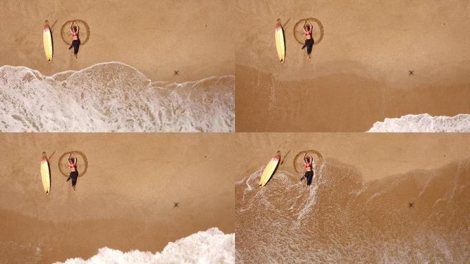 海岸线冲浪女子躺在海滩上的4K无人机视图
