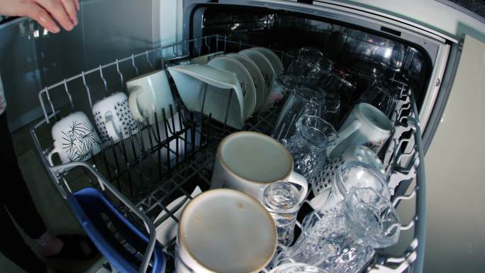 洗盘子，打扫厨房，女人把盘子放进洗碗机