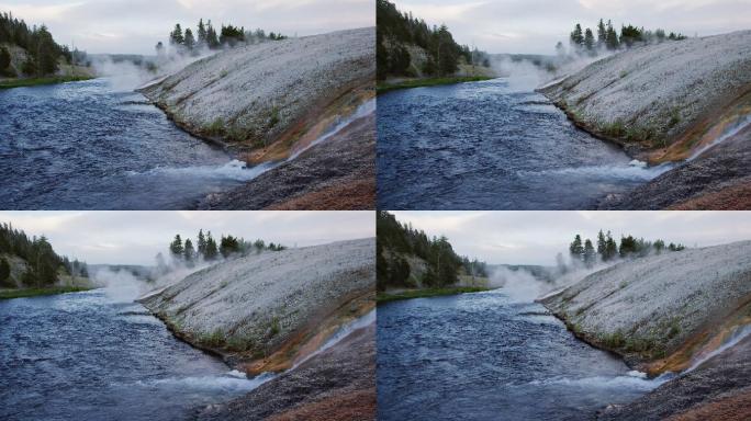 在怀俄明州黄石国家公园，水从大棱柱形泉水的岩石表面落入滚烫的火坑河的慢镜头