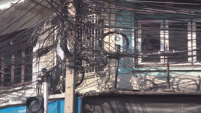 泰国曼谷街头凌乱的黑色电线，包括电线和电话通讯电缆。