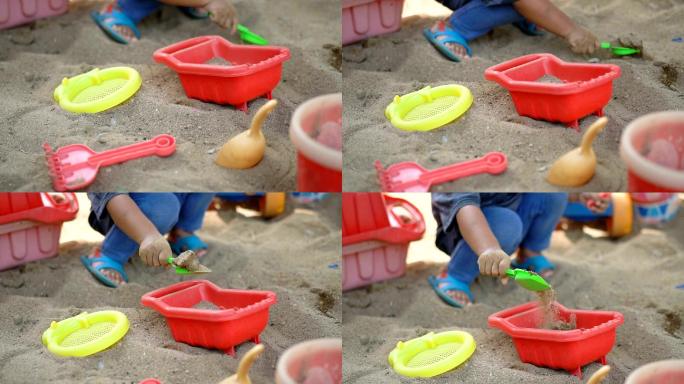 SLO MO婴儿在沙箱中玩沙子。