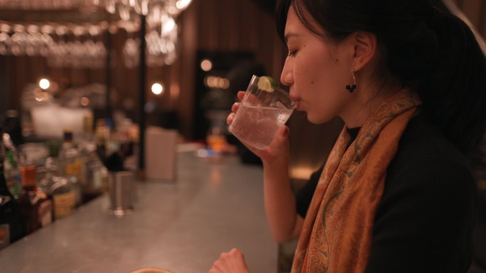亚洲女性在豪华酒吧喝鸡尾酒