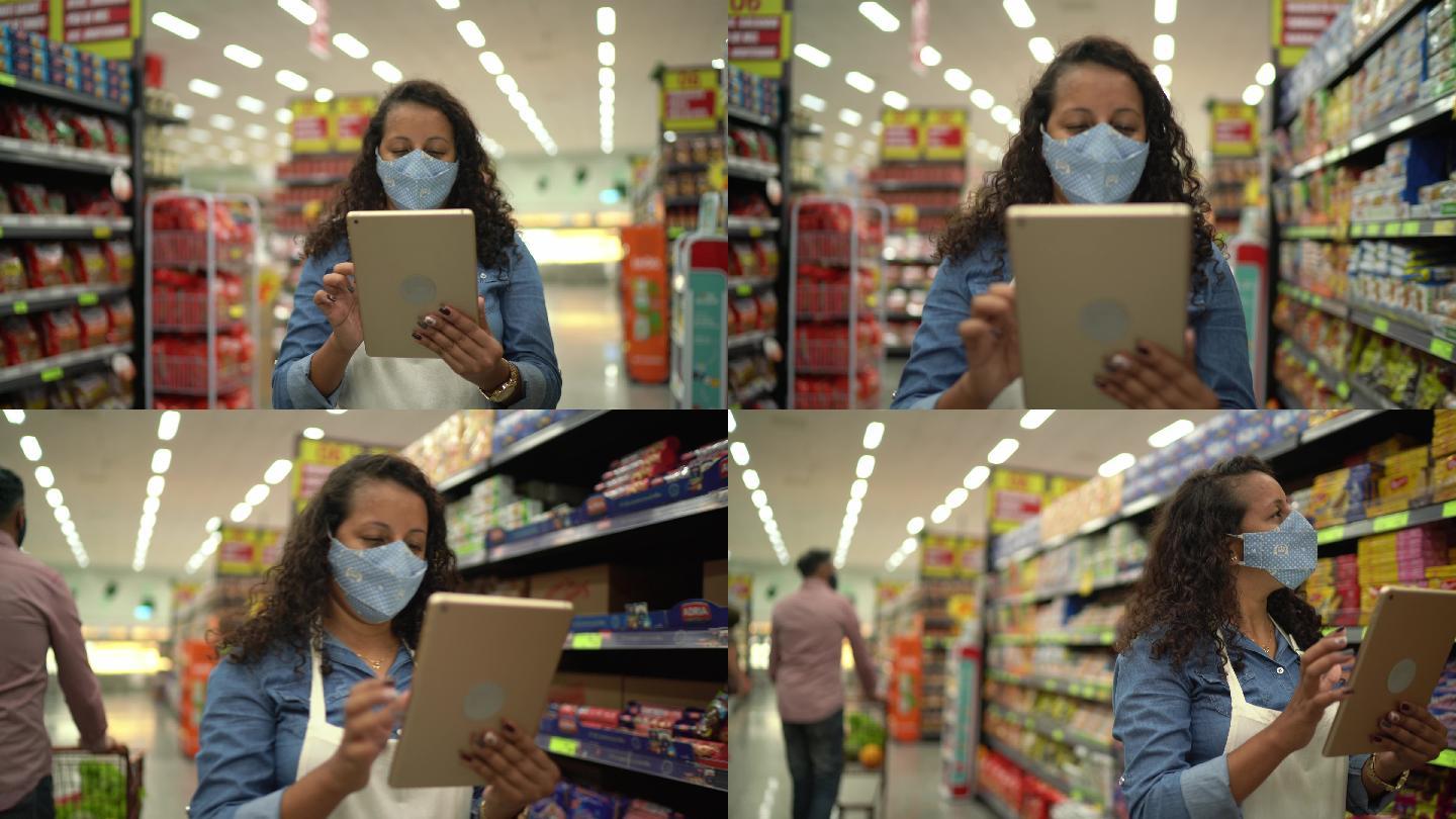 戴口罩的女性使用数码平板电脑控制超市库存