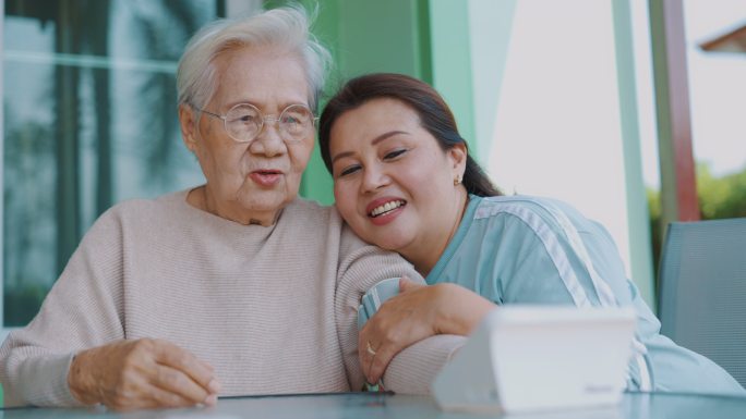 女性在家检查一位老年患者的血压
