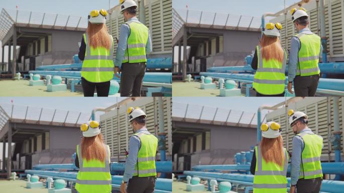 两名维修工程师，男，女，检查大楼露台上的工作，维护大楼的空调系统