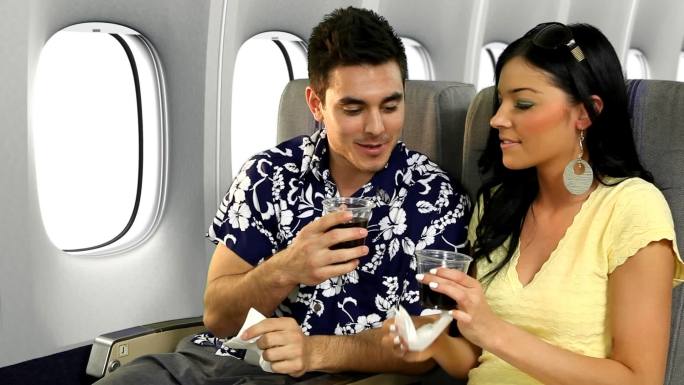 度假情侣在飞机上祝酒