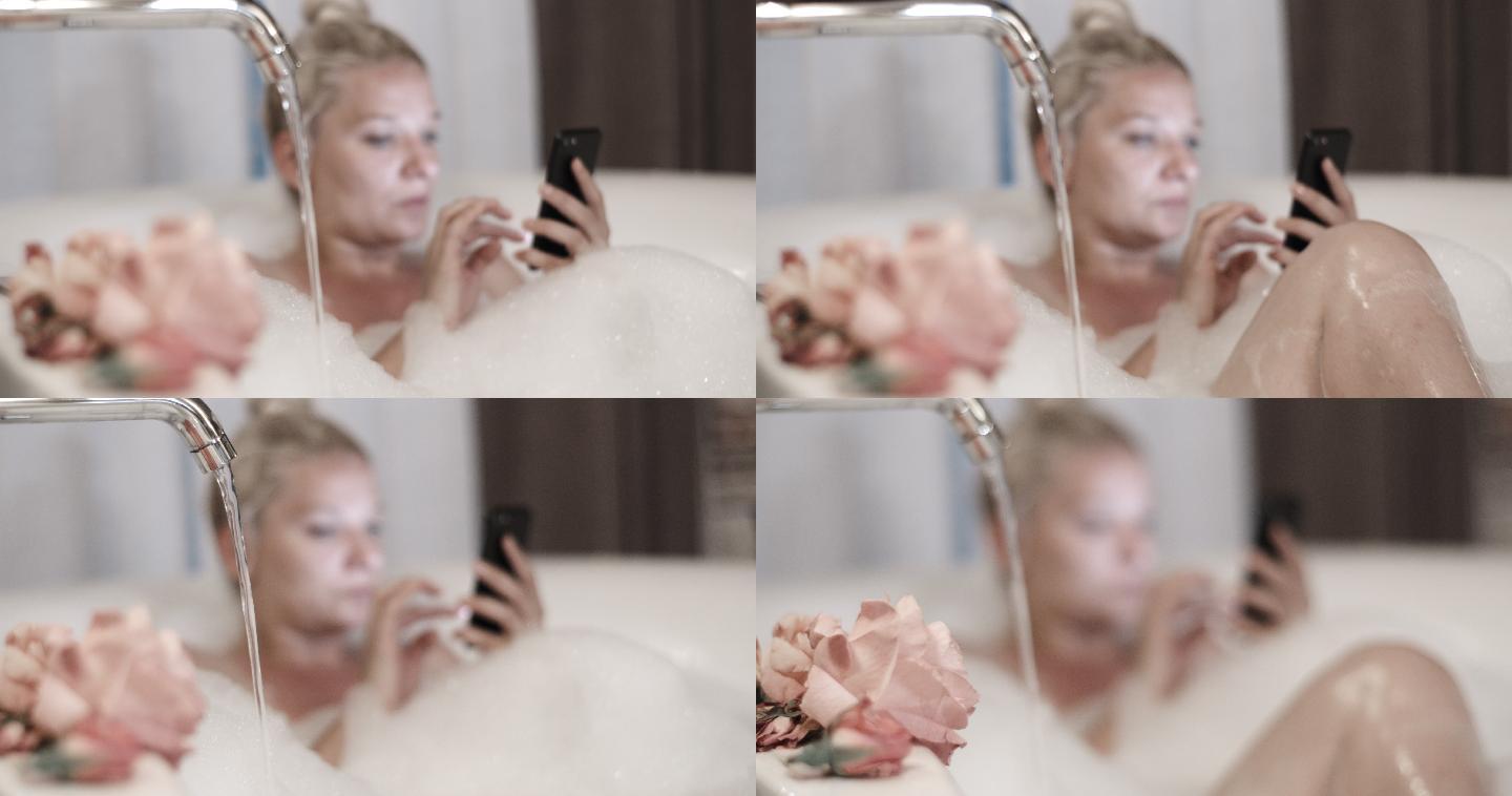 SLO MO女士在泡泡浴时使用手机