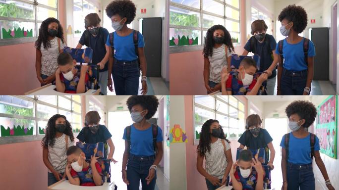孩子们在学校与一个有特殊需要的男孩走在走廊里-戴着口罩