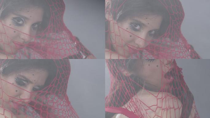 被困在红网中的性感黑发时装模特展示面部表情。时尚视频。