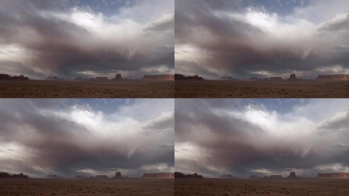 黄昏时分，在一片戏剧性的天空和沙尘暴下，无人机纪念碑山谷纳瓦霍部落公园梅里克·巴特斯和手套正迎面逼近