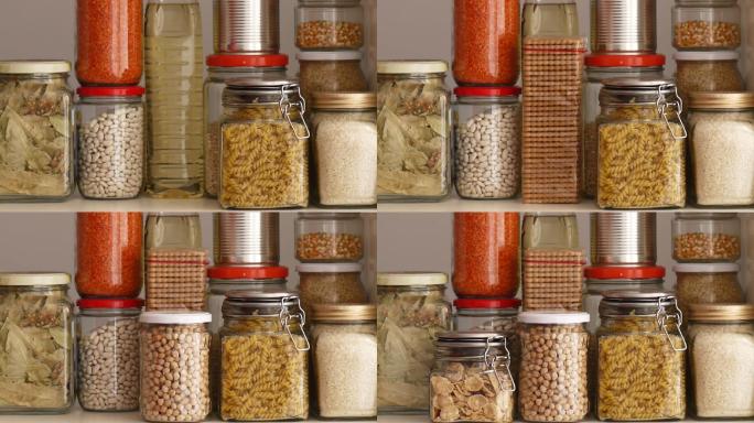 一名男子从食品储藏室的货架上取下或放置装满豆类的玻璃罐