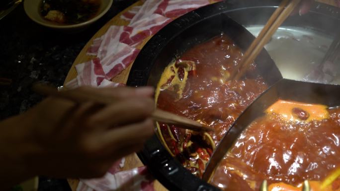 用中国麻辣火锅汤煮一片生猪肉