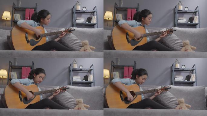 快乐的少女在家的客厅里弹原声吉他。创造性爱好