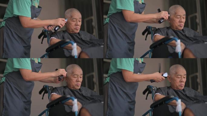 坐轮椅的亚裔中国老人在家前院理发