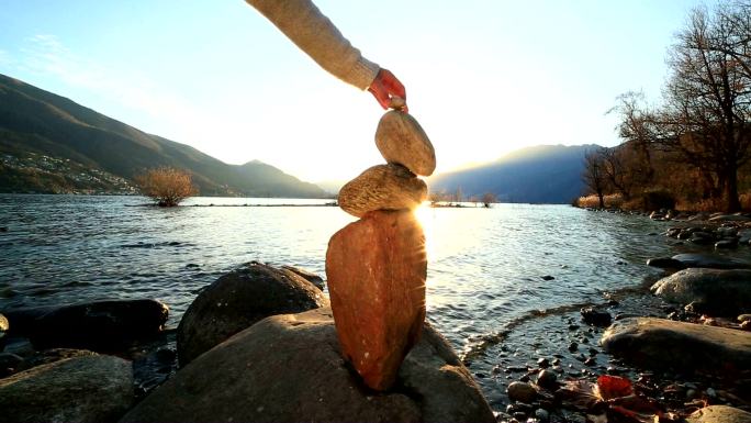 湖边堆石头的女人垒石头湖边湖水