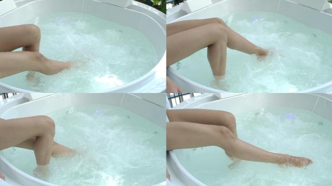 4K慢动作女性双腿在漩涡浴缸中沐浴，水上spa双腿适合热爱健康的女性。