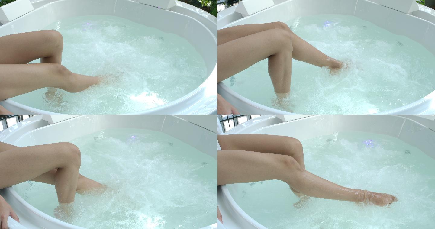 4K慢动作女性双腿在漩涡浴缸中沐浴，水上spa双腿适合热爱健康的女性。