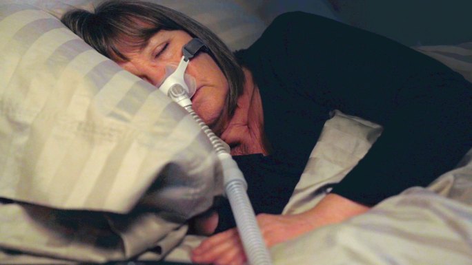 中年妇女用CPAP机治疗睡眠呼吸暂停，睡得很香
