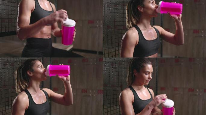 汗流浃背的女运动员在更衣室喝水。