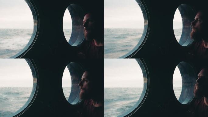在海上航行的船只舷窗旁的人