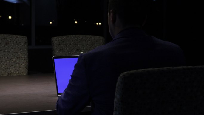 在停电期间，一位成年商人兼办公室工作人员在一个风雨交加的夜晚用笔记本电脑拍摄4K视频系列