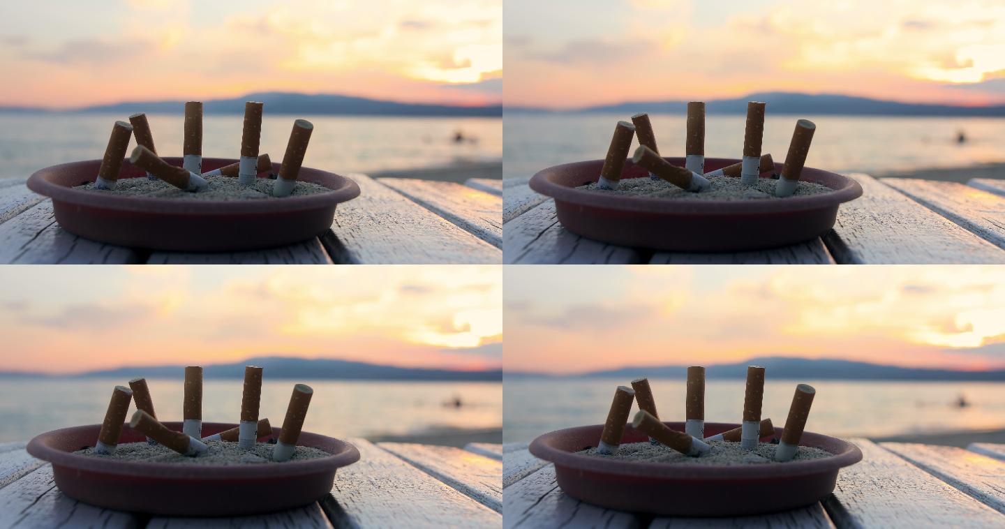 海上烟灰缸里的烟头。希腊美丽的日落