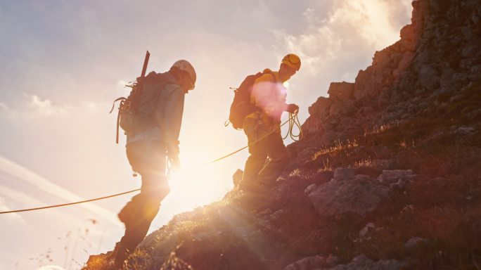 TD登山运动员在日落时缓慢走向山顶