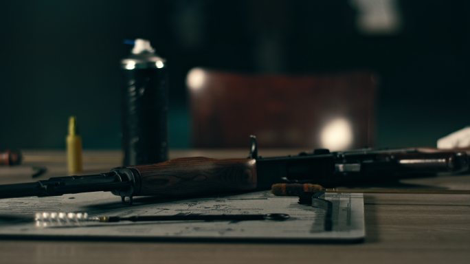 AK-47枪和清洁配件放在桌子上。随时可用