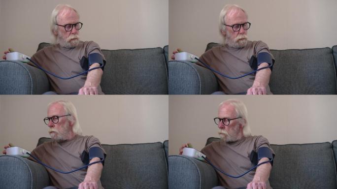 坐在沙发上检查血压的退休男子