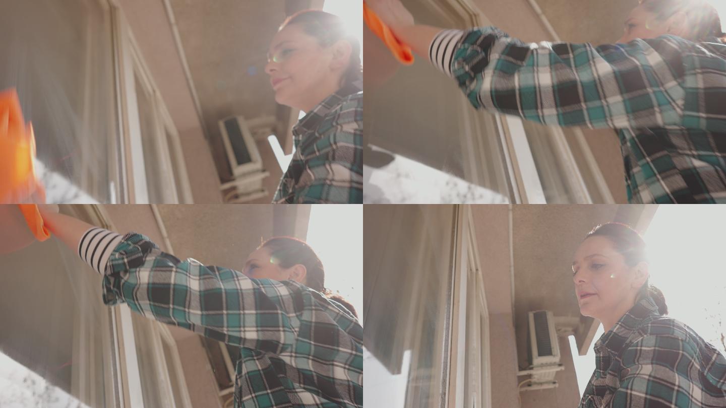 勤劳的女人做家务，用抹布擦窗户，用喷雾瓶清洁产品
