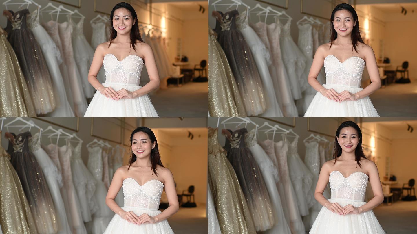 慢镜头新娘肖像摆姿势看着相机在婚纱店微笑着试穿婚纱
