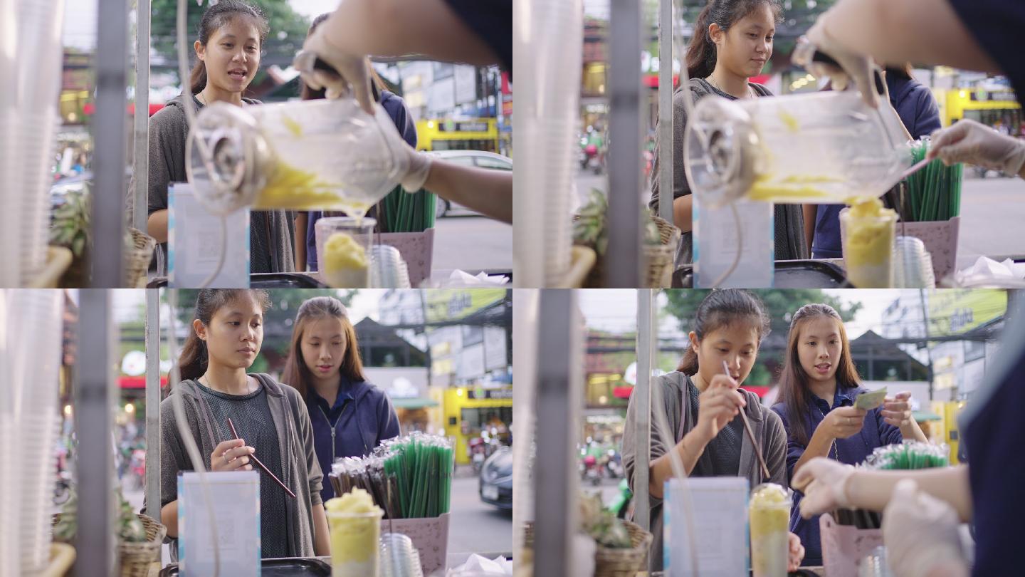 市场小贩从搅拌机里倒出水果冰沙。泰国街头小吃摊。