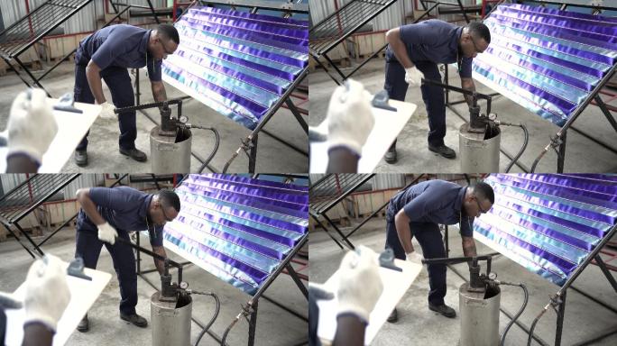 在太阳能电池板工厂，非裔美国人主管监督工人将水泵入电池板进行测试