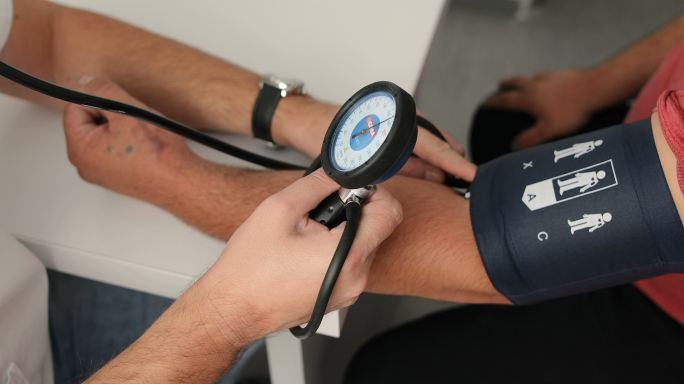 医生测量男性患者血压