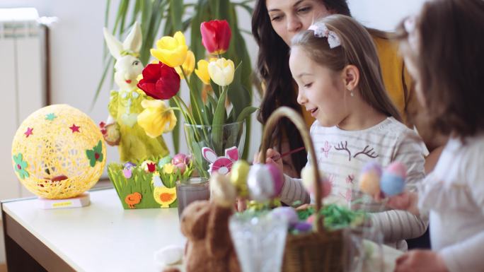 复活节快乐！一位母亲和她的小女儿给复活节彩蛋着色。股票视频